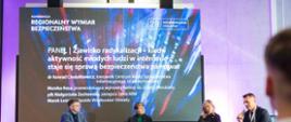 Na zdjęciu siedzą od lewej: Konrad Ciesiołkiewicz, płk Małgorzata Żochowska, posłanka Monika Rosa oraz Marek Leśniak. W tle ścianka multimedialna. 