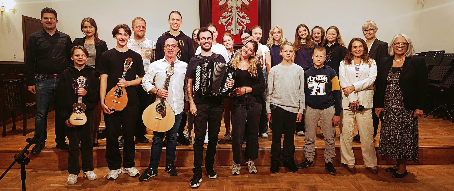 uczniowie naszej szkoły wraz z nauczycielami oraz gośćmi z Portugalii na scenie w sali królewskiej PSM Mielec