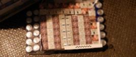 Na podłodze paczki z nielegalnymi papierosami wśród puszek z napojami gazowanymi