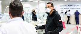 Premier Mateusz Morawiecki rozmawia z lekarzem.