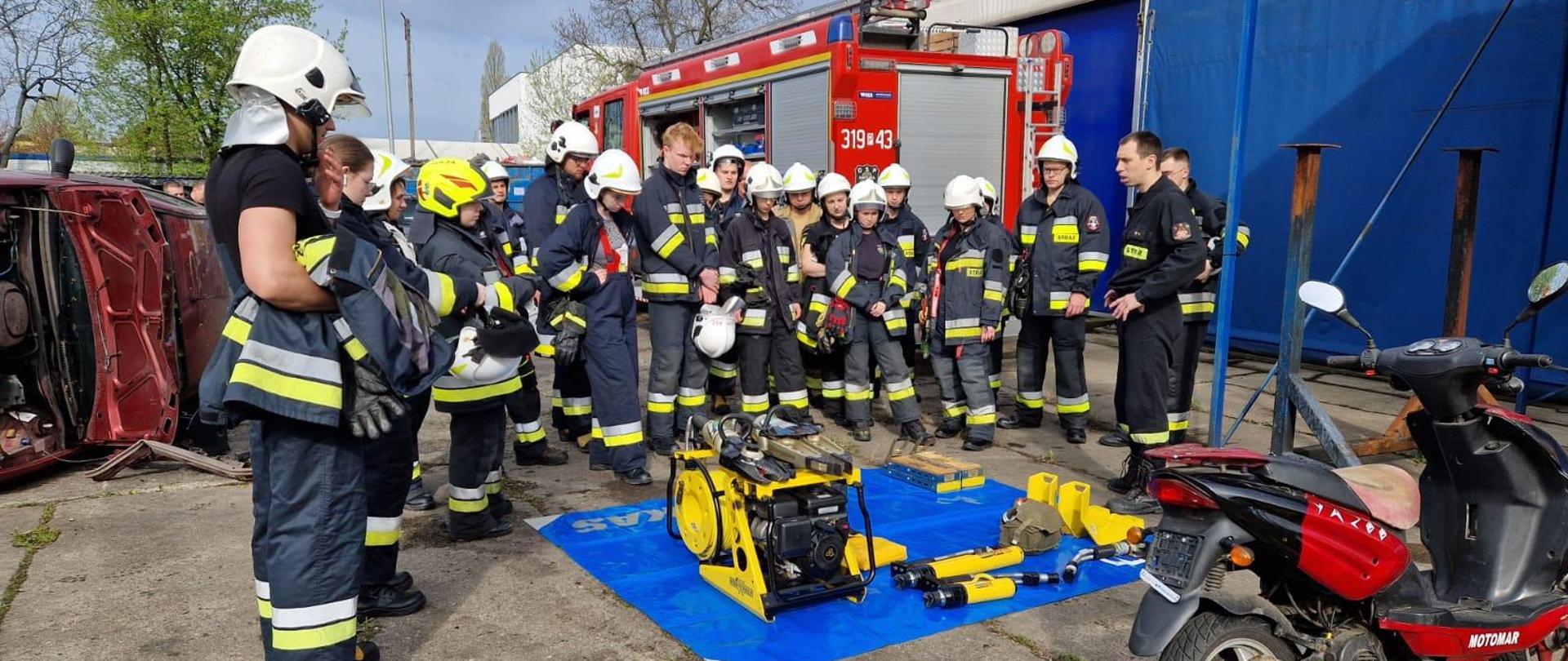 Strażacy w trakcie omawiania zasad użytkowania sprzętu hydraulicznego