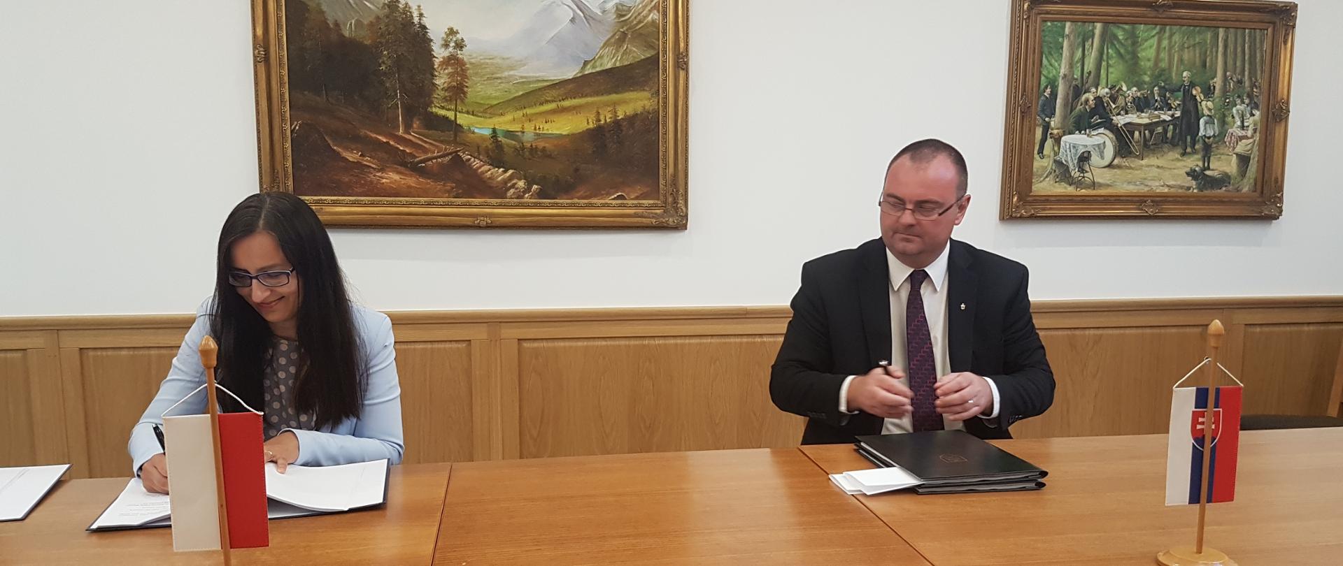 Przedstawicielka polskiej delegacji oraz przedstawiciel strony słowackiej podpisują dokument porozumienia ws Wód Granicznych