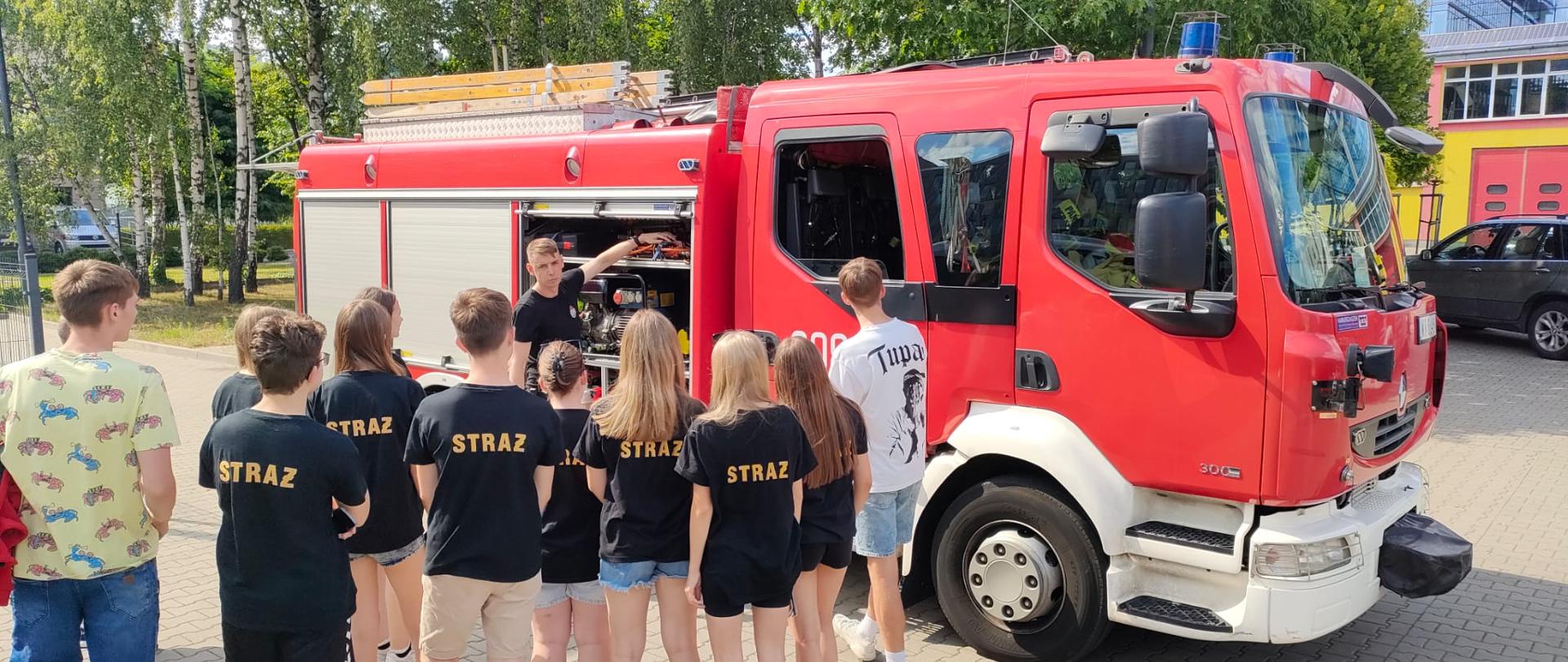 Dzieci tyłem oglądające prezentacje samochodu pożarniczego