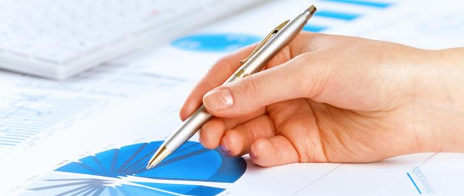 Dłoń trzymająca długopis