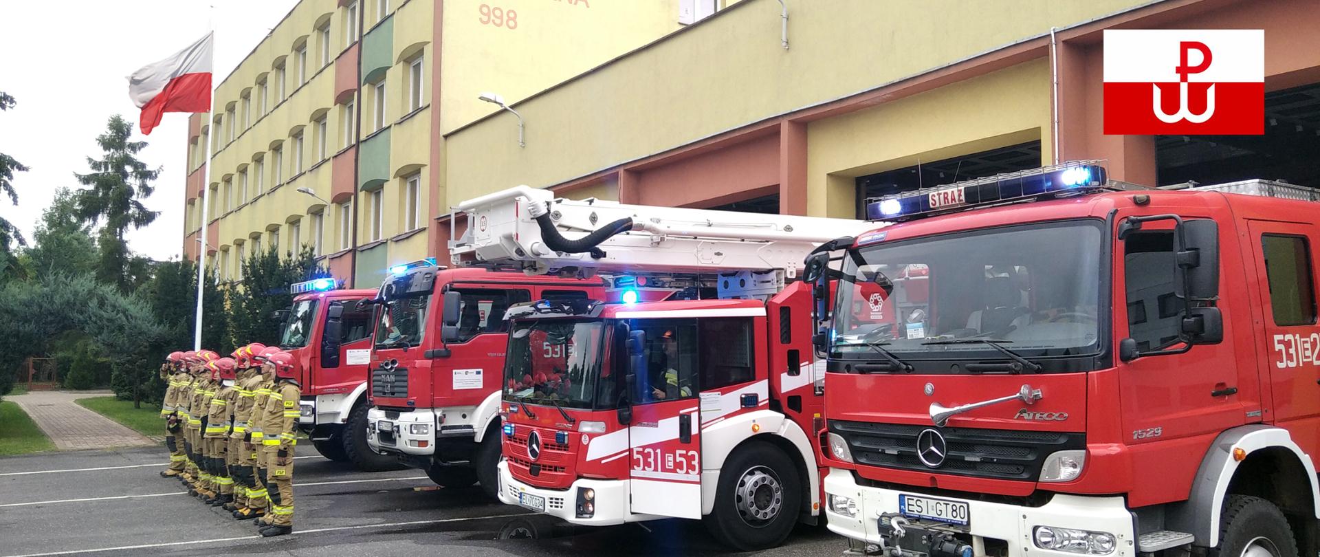 Na zdjęciu widać strażaków z JRG Sieradz stojących przed samochodami pożarniczymi. Strażacy stoją na uroczystej zbiórce upamiętniając 77 rocznicę wybuchu Powstania Warszawskiego