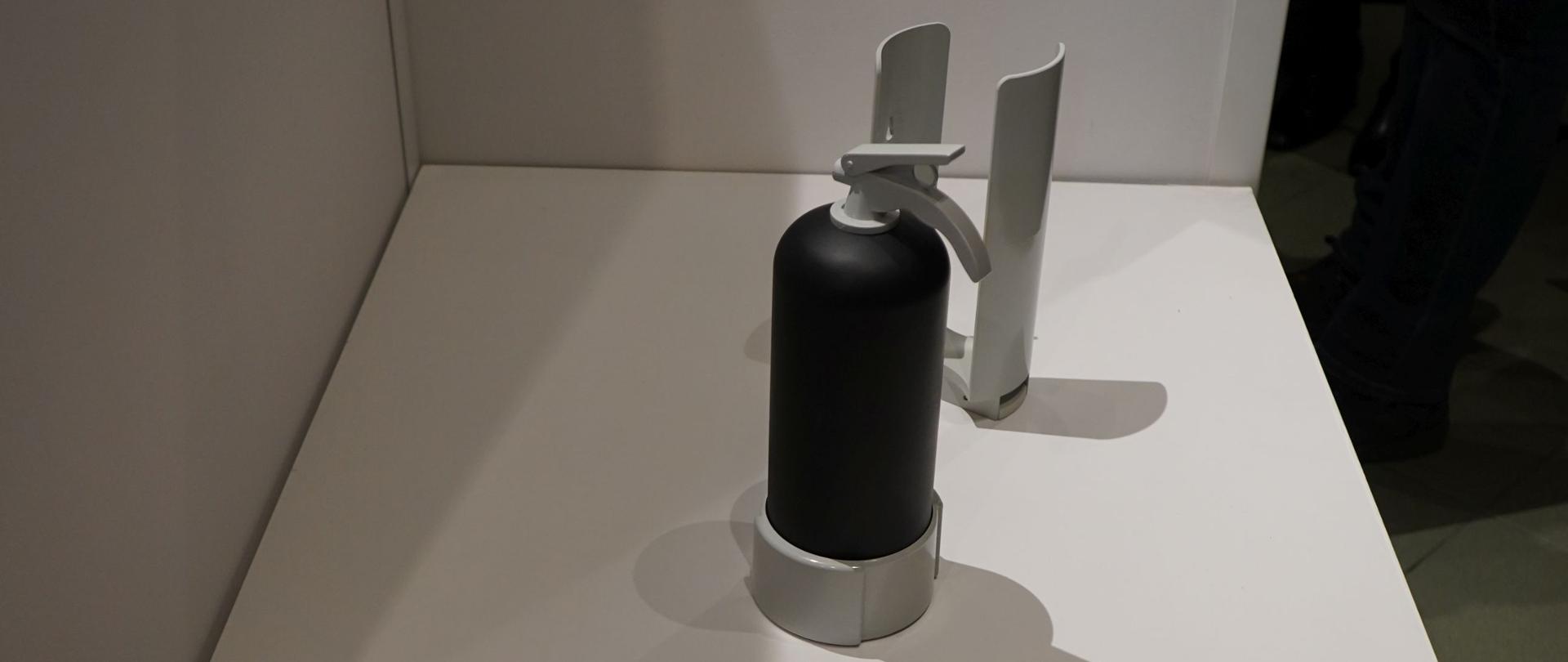 czarna gaśnica a obok leżą biało czerwone teczki z napisem państwowa straż pozarna