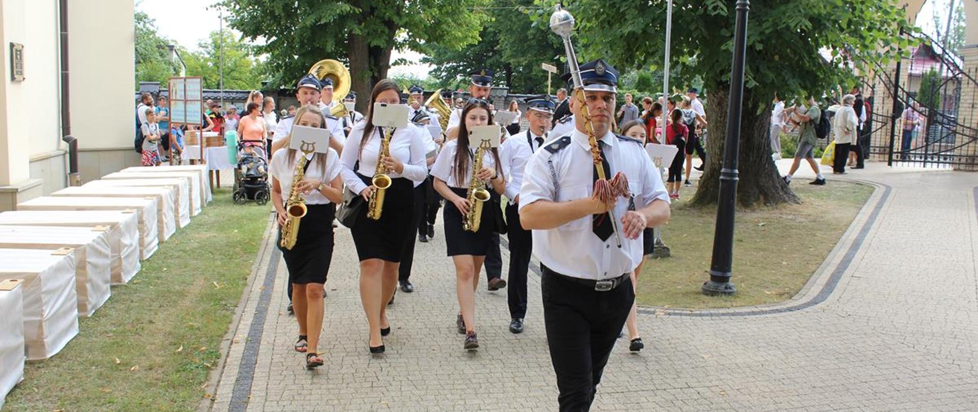 Na zdjęciu widzimy orkiestrę OSP, która odgrywa melodię w trakcie przemarszu przy Sanktuarium
