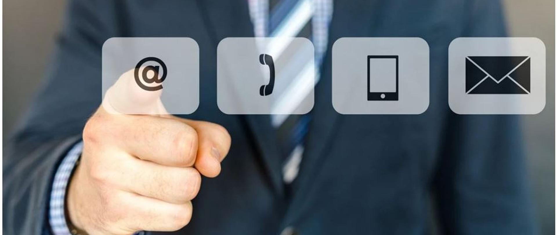 Na zdjęciu widać w tle mężczyznę w garniturze w krawacie (zdjęcie tylko od pasa do szyi). Wskazuje on palcem na 4 ikonki: skrzynki mailowej, telefonu, strony internetowej oraz adresu pocztowego.