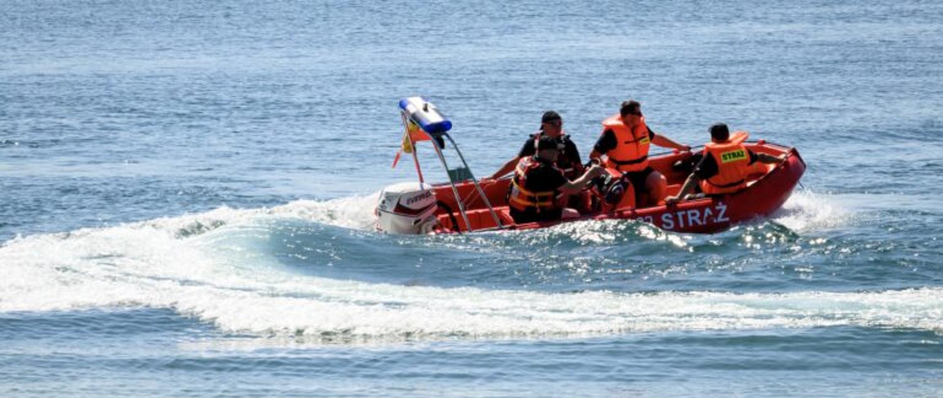 Zdjęcie przedstawia łódkę z ratownikami na wodzie