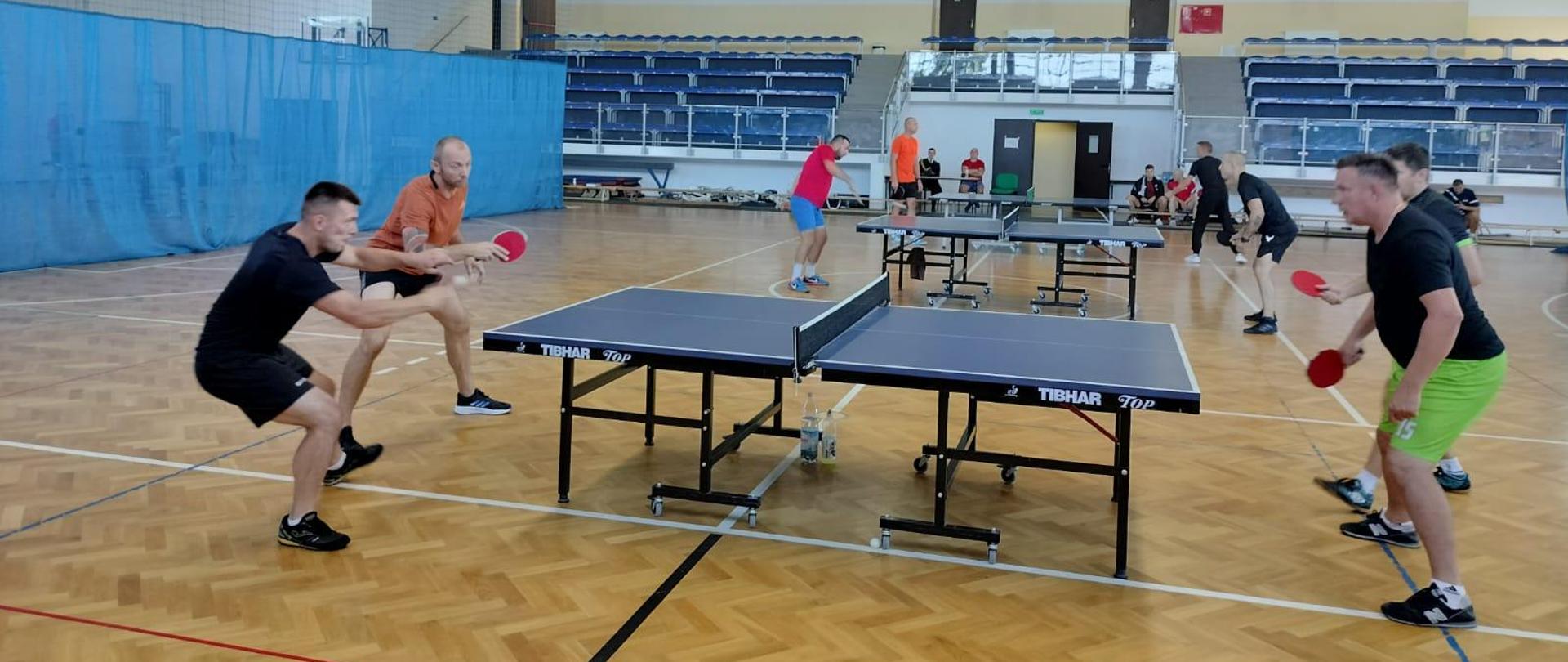 Na zdjęciu strażacy podczas meczu tenisa stołowego.