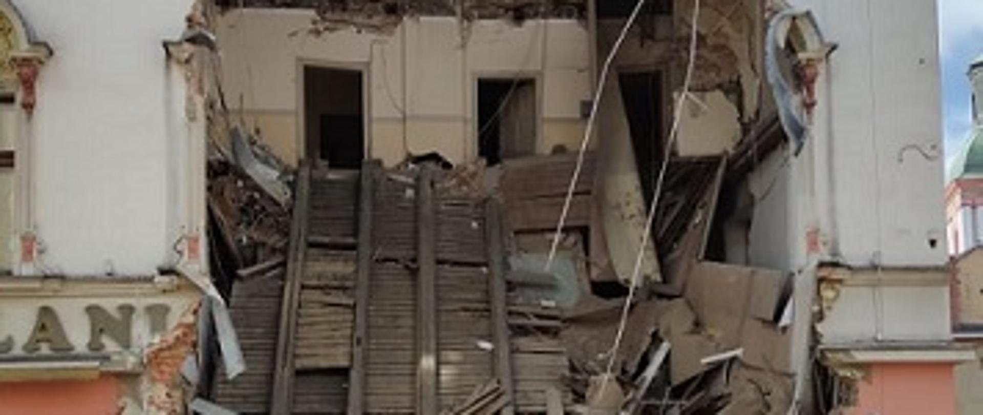 Zdjęcie przedstawia kamienicę i widoczne uszkodzenia budynku na skutek zawalenie się części ściany frontowej i stropów w budynku.