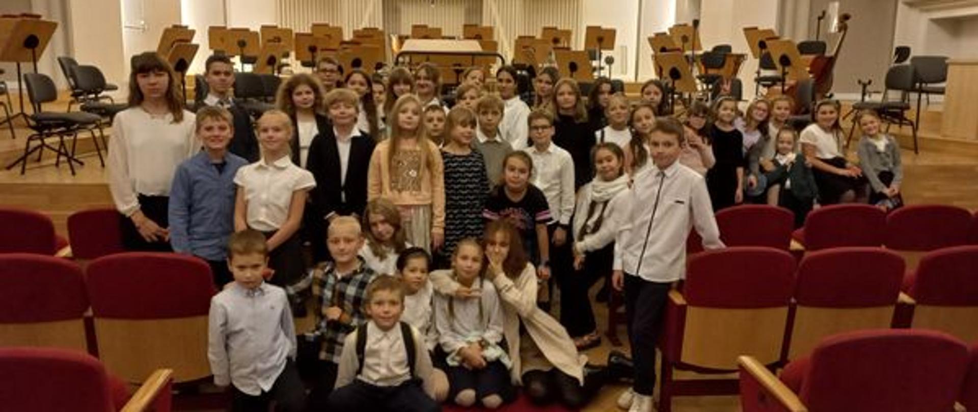 Grupa dzieci stoi pod sceną Filharmonii Śląskiej w Katowicach