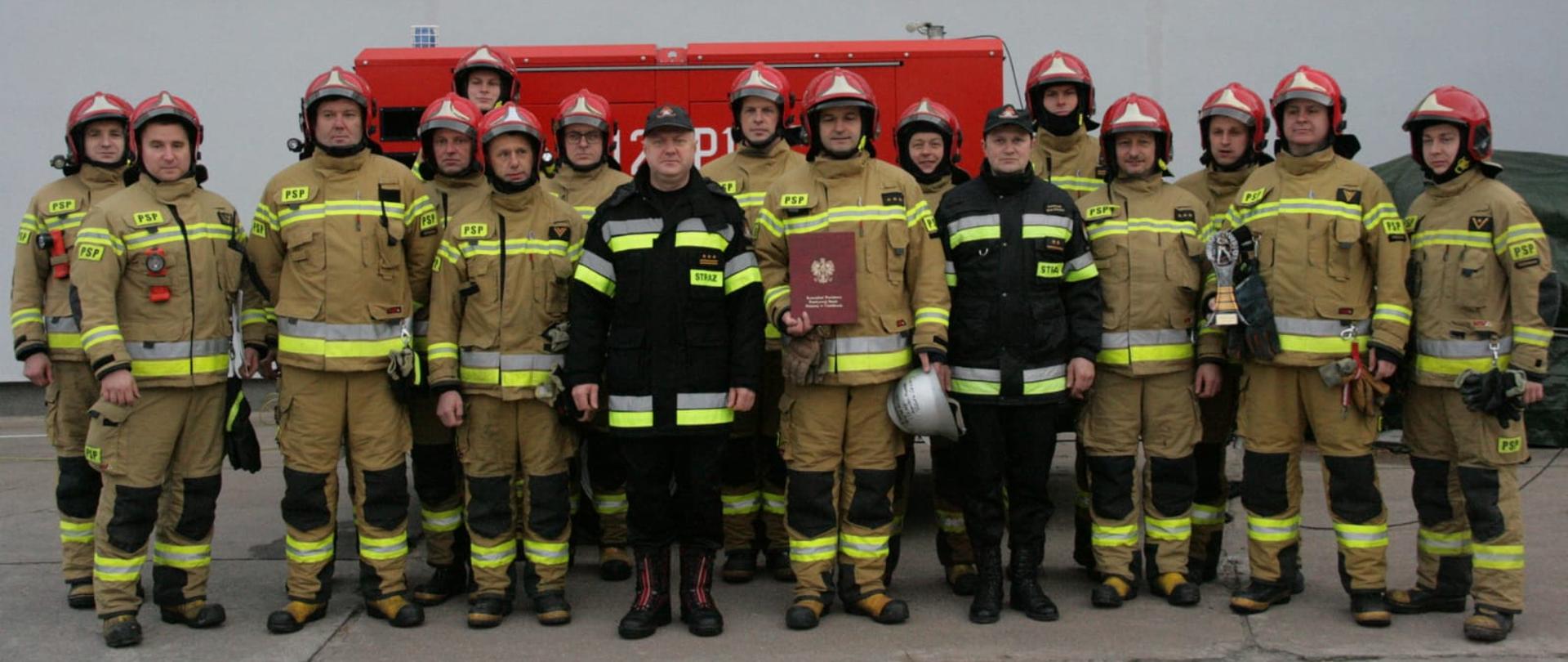 Strażacy stoją z Komendantem i Dowódcą Jednostki Ratowniczo-Gaśniczej