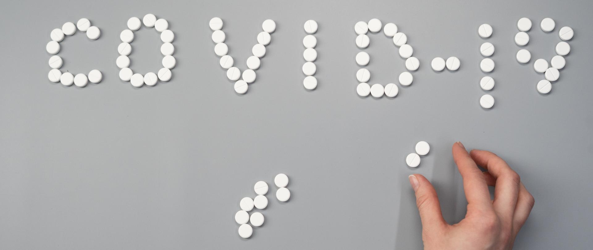 Napis Covid-19 ułożony z tabletek, fot.: cottonbro