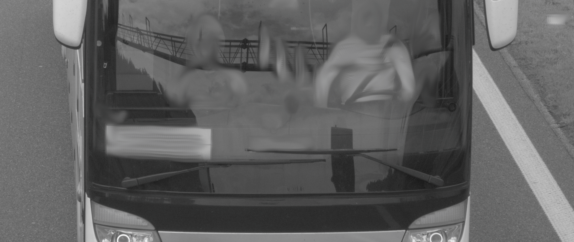 Przód autobusu. Za kierownicą siedzi mężczyzna