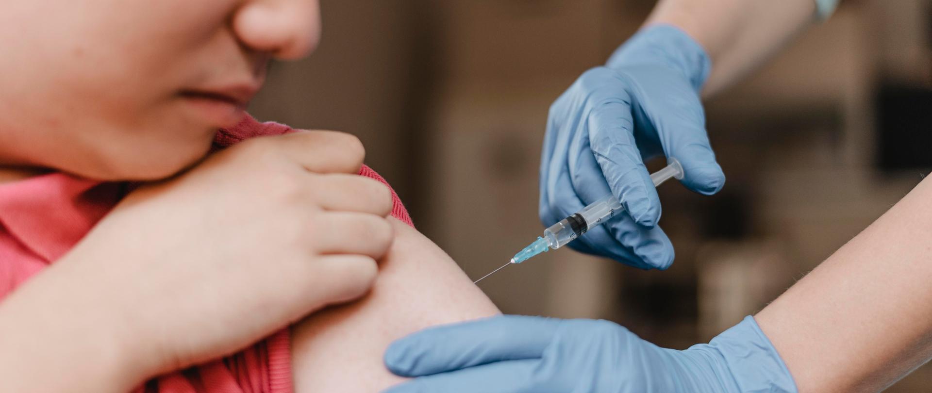 lekarz-w-rekawiczkach-i-daje-dziecku-szczepionke