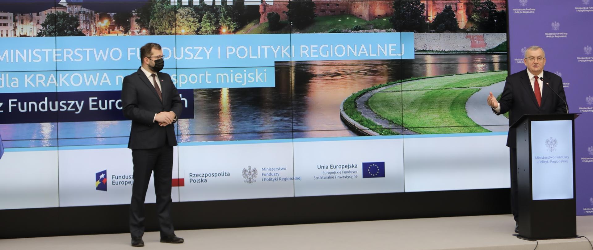 Na scenie w mównicy minister Andrzej Adamczyk. Obok minister Grzegorz Puda. Za nimi na ekranie napis - 33 mln zł.