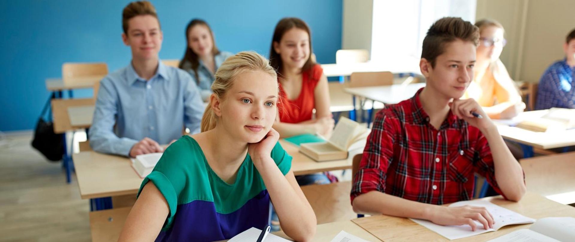 Klasa z siedzącymi w ławkach uczniami