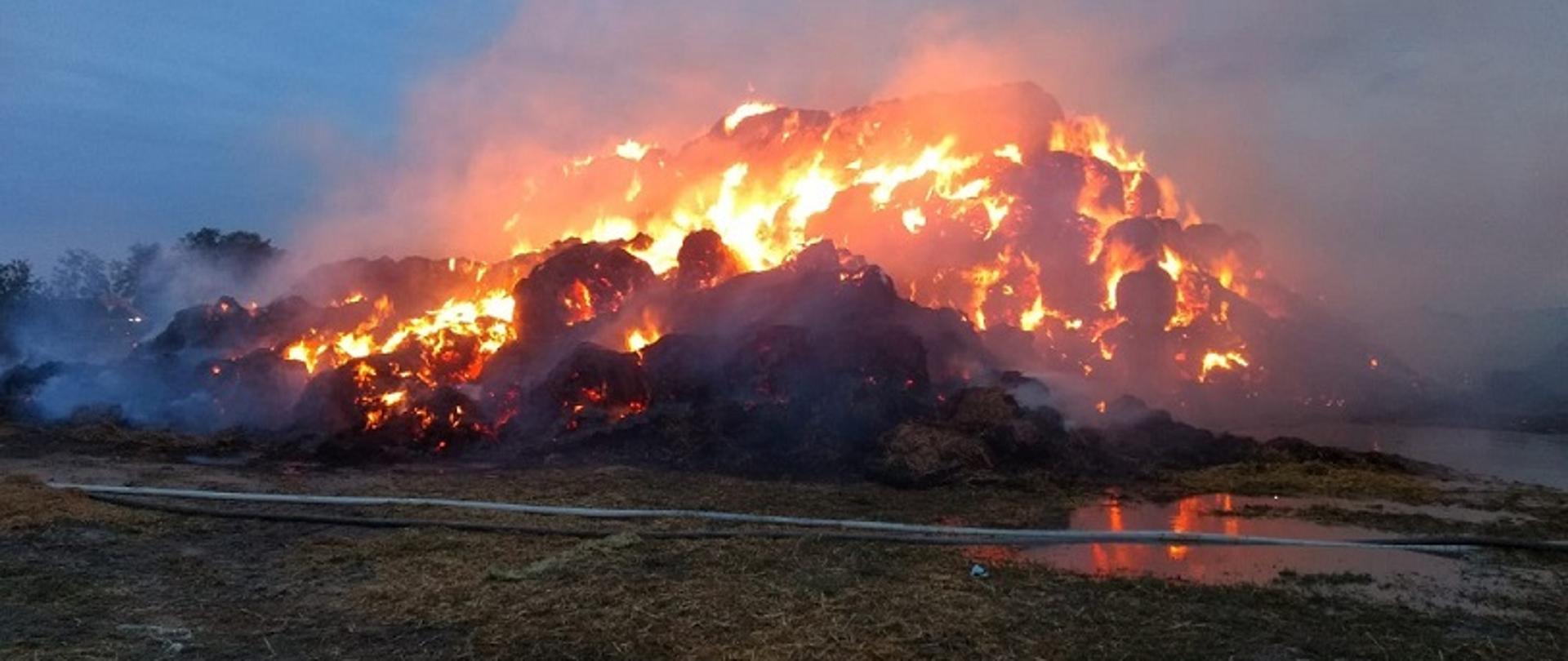 Zdjęcie przedstawia pożar sterty słomy