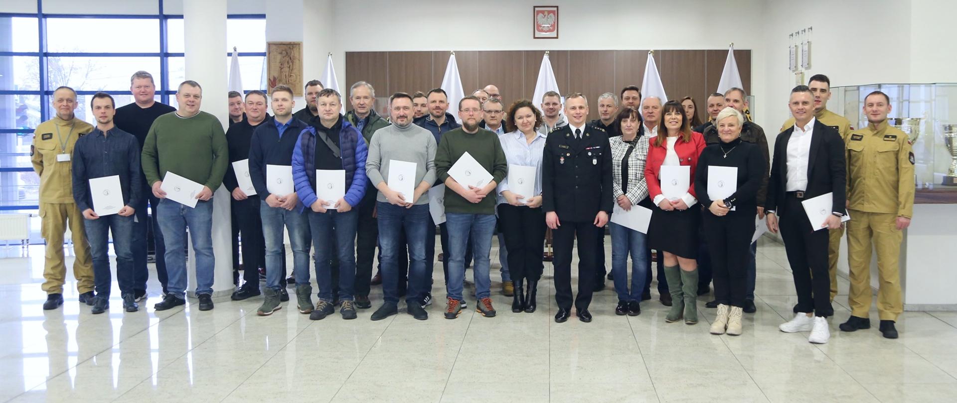 Grupowe zdjęcie uczestników szkolenia (28 osób) w towarzystwie Zastępcy Komendanta CS PSP oraz trzech oficerów CS PSP