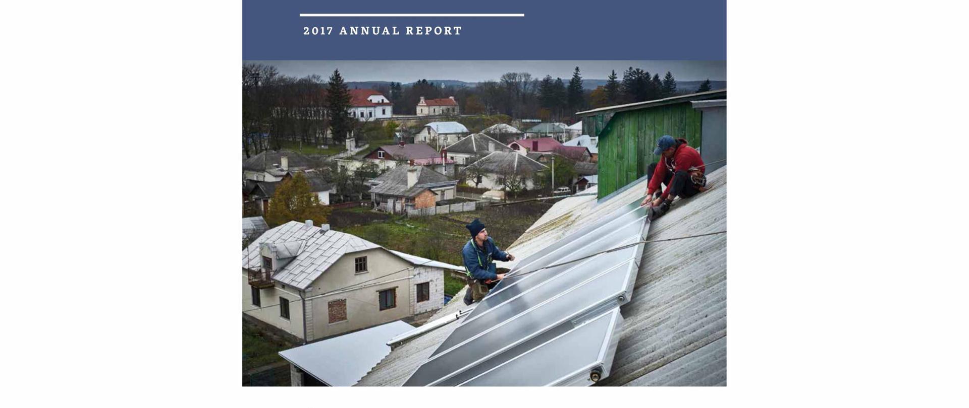 cover of publication with two men are sitting on the roof and they are installing solar system with the title Polish Development Coorperation - 2017 Annual Report