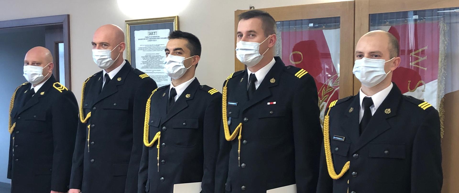 Awansowani z wręczonymi aktami.