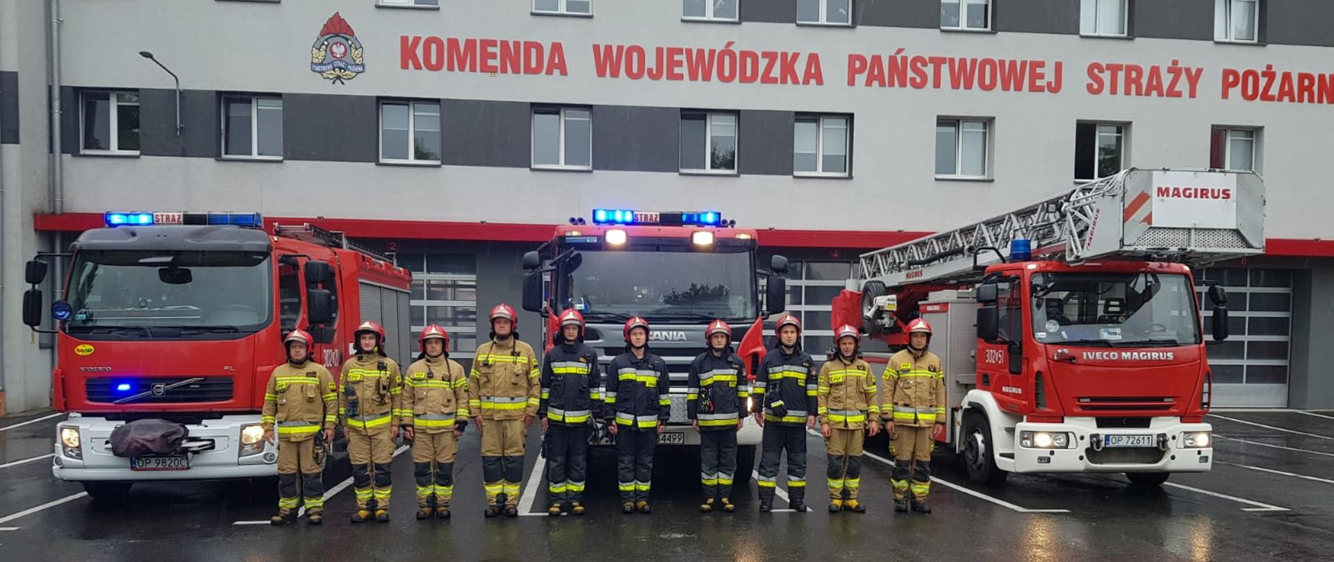 Na zdjęciu widoczni są strażacy na tle samochodów z włączoną sygnalizacją świetlną upamiętniający 77. rocznicę Powstania Warszawskiego