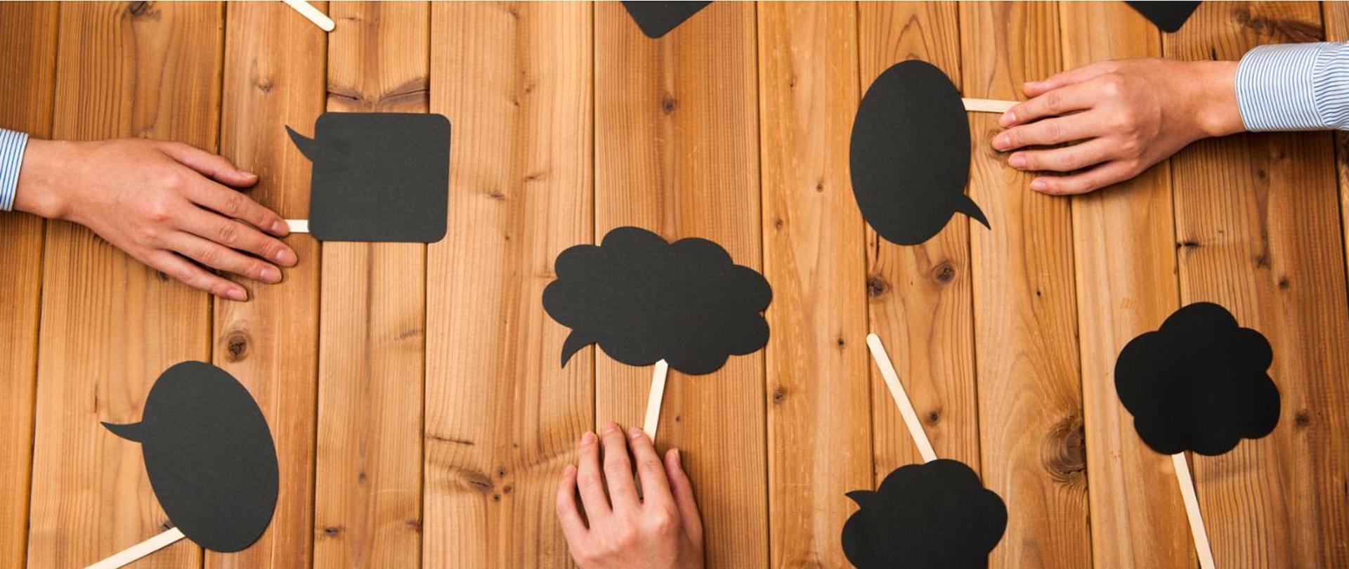 czarne dymki czatu na podpórkach położone na płasko na drewnianym tle