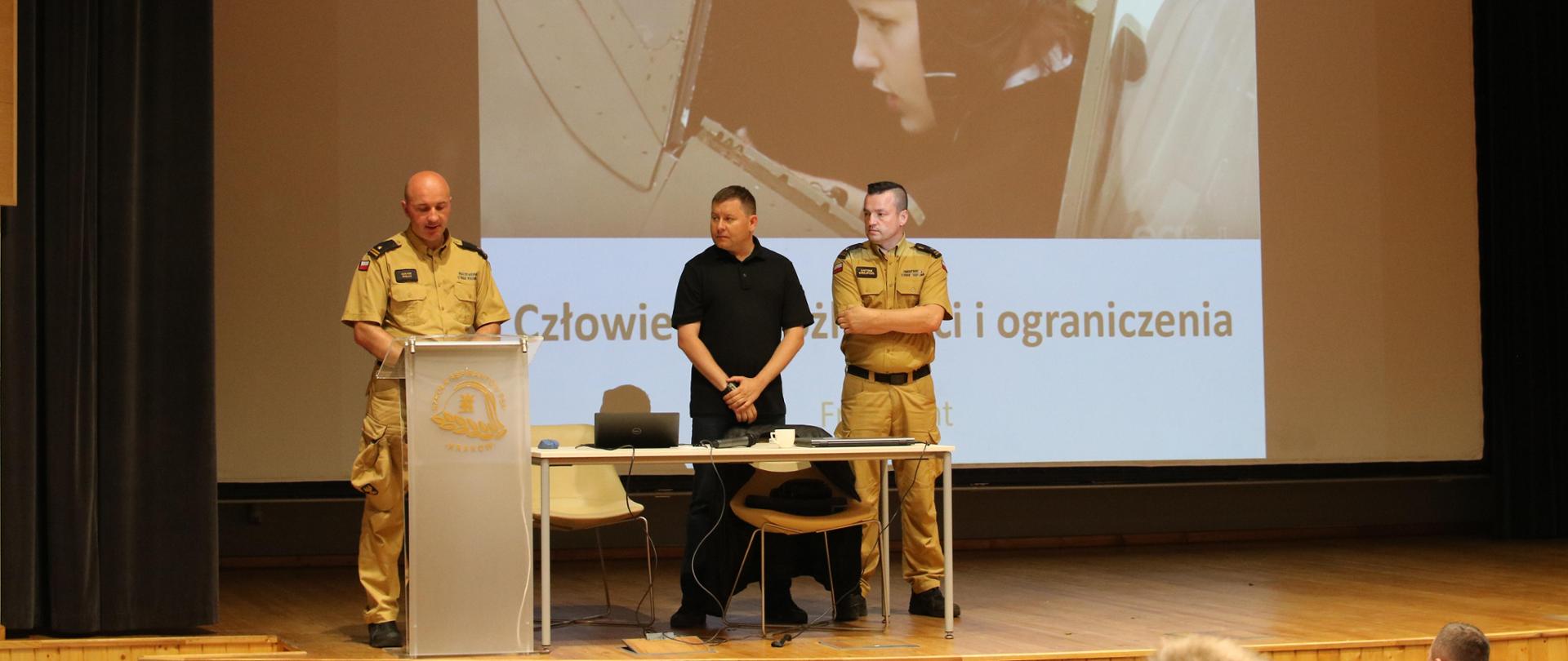 Warsztaty tematyczno – metodyczne. Na scenie stoją osoby prezentujące zdjęcia 