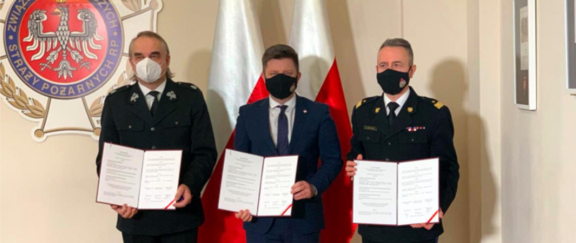 Na zdjęciu widnieją: Michał Dworczyk, szef Kancelarii Prezesa Rady Ministrów, nadbryg. Andrzej Bartkowiak, komendant główny PSP i dh. Waldemar Pawlak prezes ZG ZOSP RP.