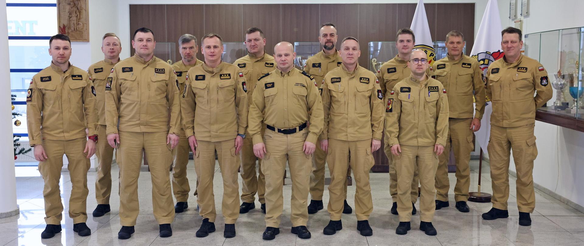 Pamiątkowe zdjęcie grupowe funkcjonariuszy PSP będących uczestnikami narady służbowej (12 osób) w towarzystwie Zastępcy Komendanta Centralnej Szkoły PSP