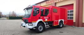 Nowy średni samochód ratownictwa wodnego stoi na placu JRG przed garażem - widok na lewy bok.