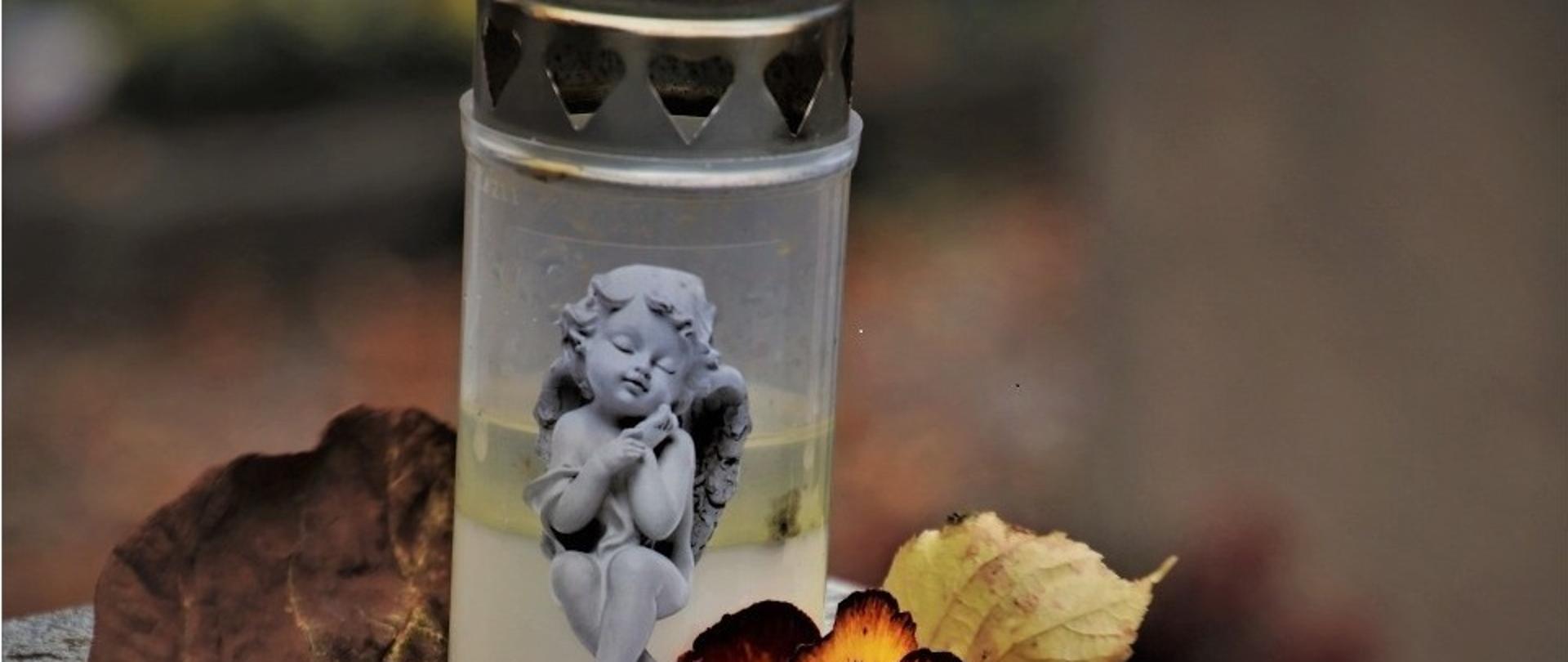 Znicz z aniołkiem na grobie