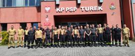 Uczestnicy szkolenia pozują do zdjęcia przed budynkiem Komendy Powiatowej Państwowej Straży Pożarnej w Turku. 