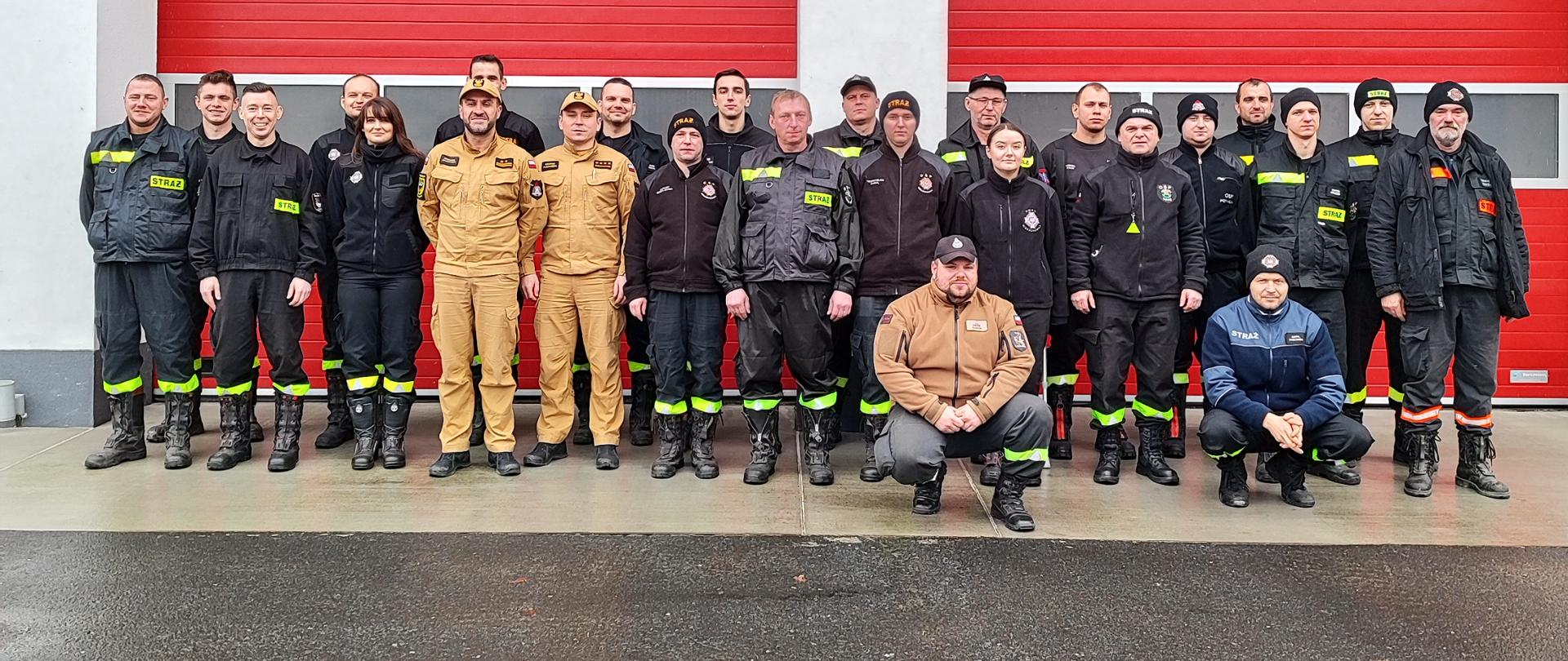 Na zdjęciu widać osoby które przystąpiły do egzaminu dla dowódców OSP wraz z komisją egzaminacyjną, stoją oni przed Komendą Powiatową Państwowej Straży Pożarnej w Miliczu.