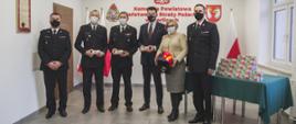 Na zdjęciu strażacy z Państwowej Straży Pożarnej w mundurach wyjściowych pomiędzy strażakami stoją w ubraniach cywilnych Pani Poseł i Burmistrz Gorlic.