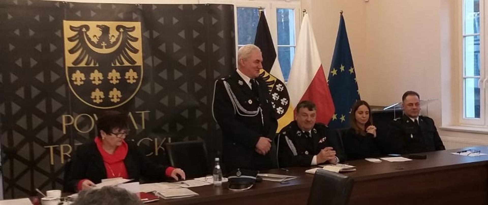 Siedzący przy stole strażacy zarządzający związkiem wraz z starosta powiatu i Komendantem straży pożarnej