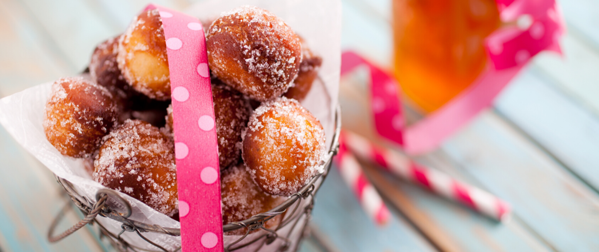 Małe pączki w eleganckim pudełku z różową wstążką. 