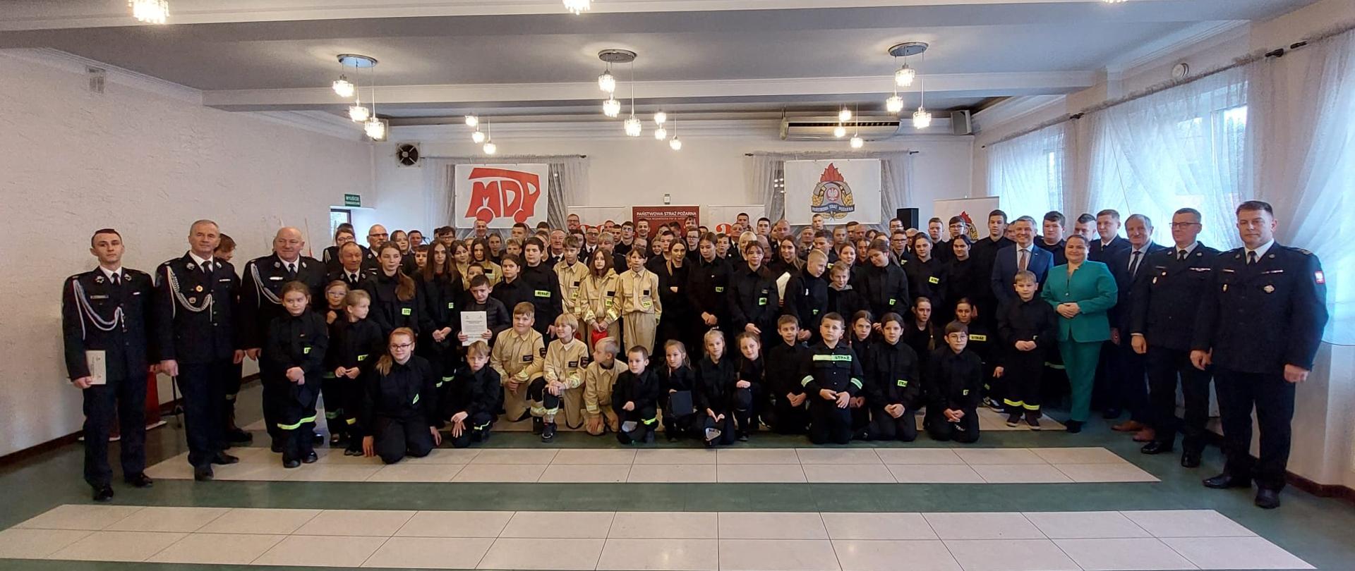 Wspólne zdjęcie Młodzieżowych Drużyn Pożarniczych OSP, które dziś odebrały promesy z oficjelami.