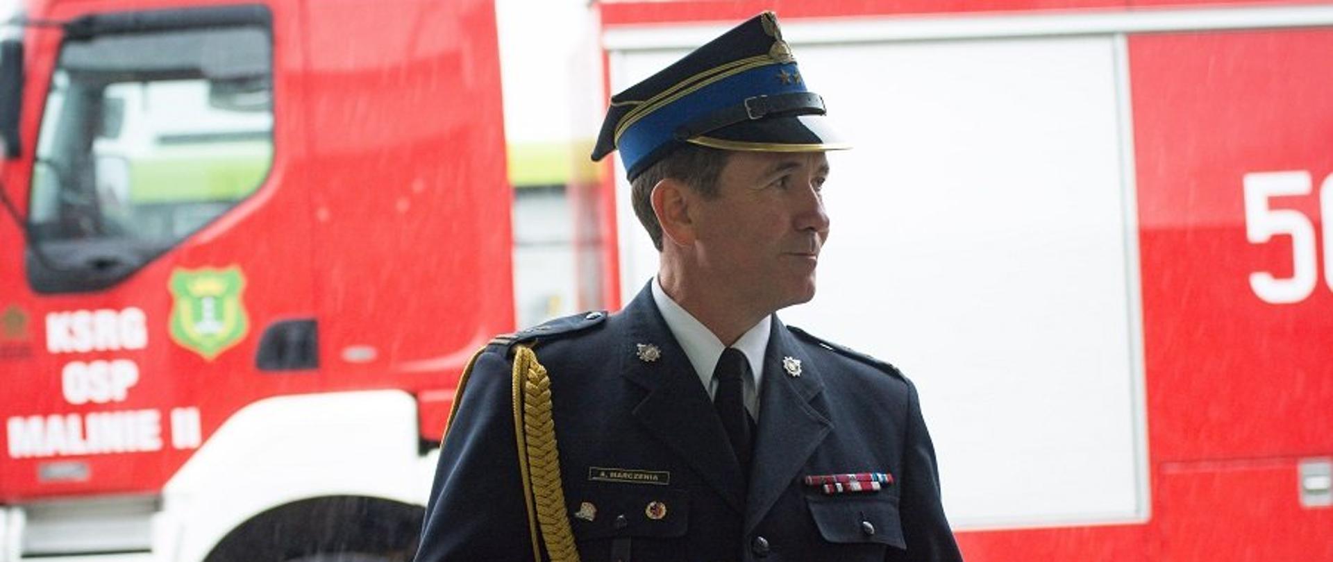 Na zdjęciu, na tle samochodu ratowniczo-gaśniczego zastępca komendanta wojewódzkiego PSP bryg. Andrzej Marczenia w mundurze galowym.