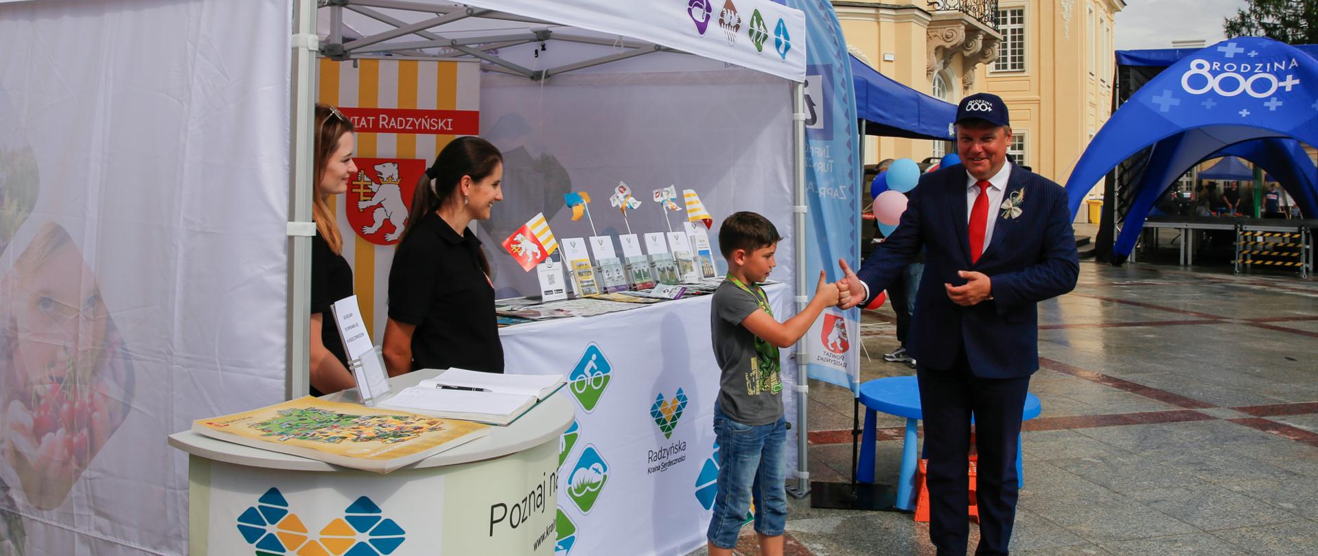 Wicewojewoda lubelski Robert Gmitruczuk przybija "piątkę" z nastolatkiem na pikniku rodzinnym 800 plus w Radzyniu Podlaskim.