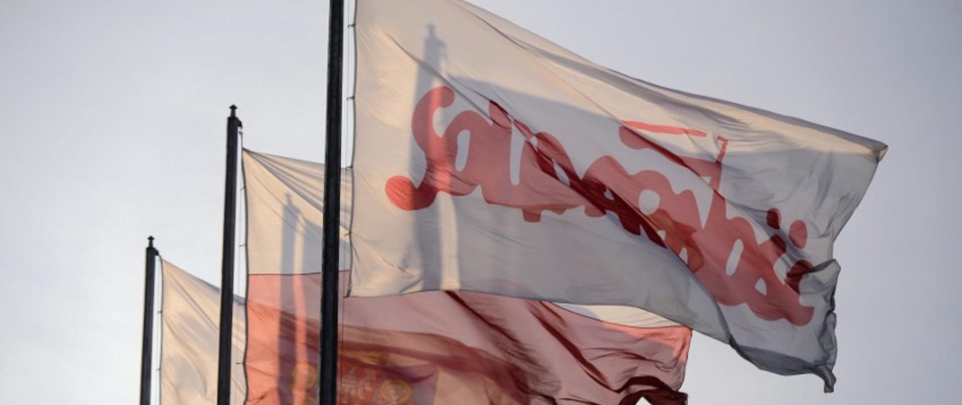 Na pierwszym planie na maszcie powiewająca flaga solidarności, dalej flaga Rzeczpospolitej Polskiej oraz Urzędu Miasta Poznania