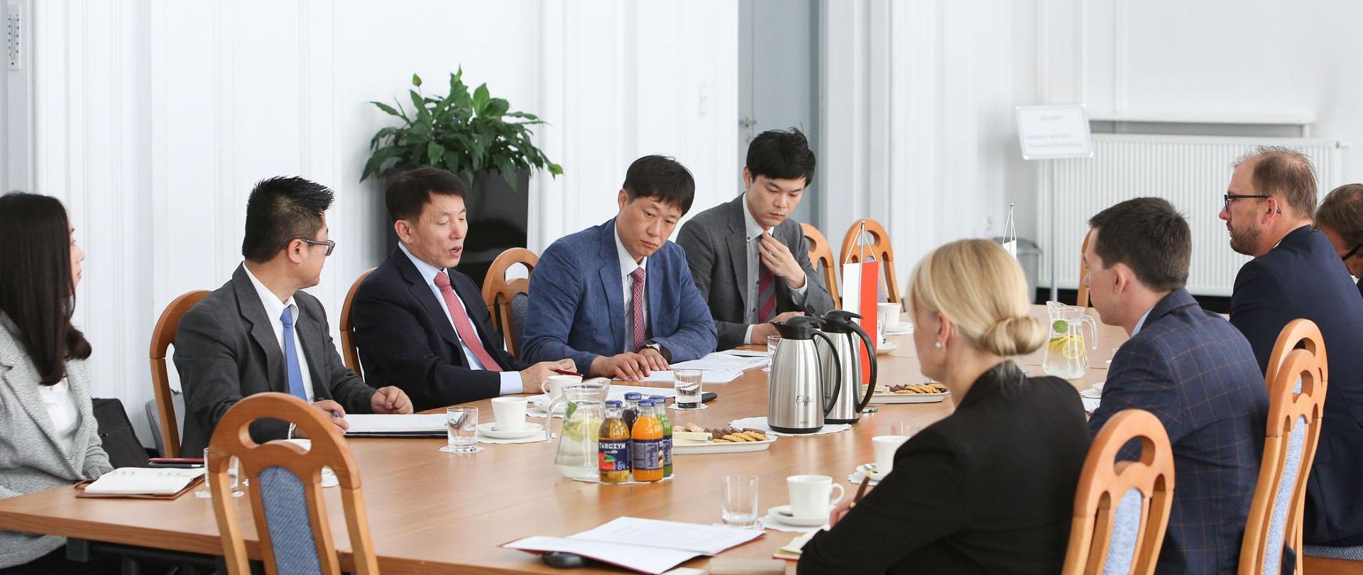 Delegacja koreańska siedzi za stołem naprzeciwko przedstawicieli MNiSW