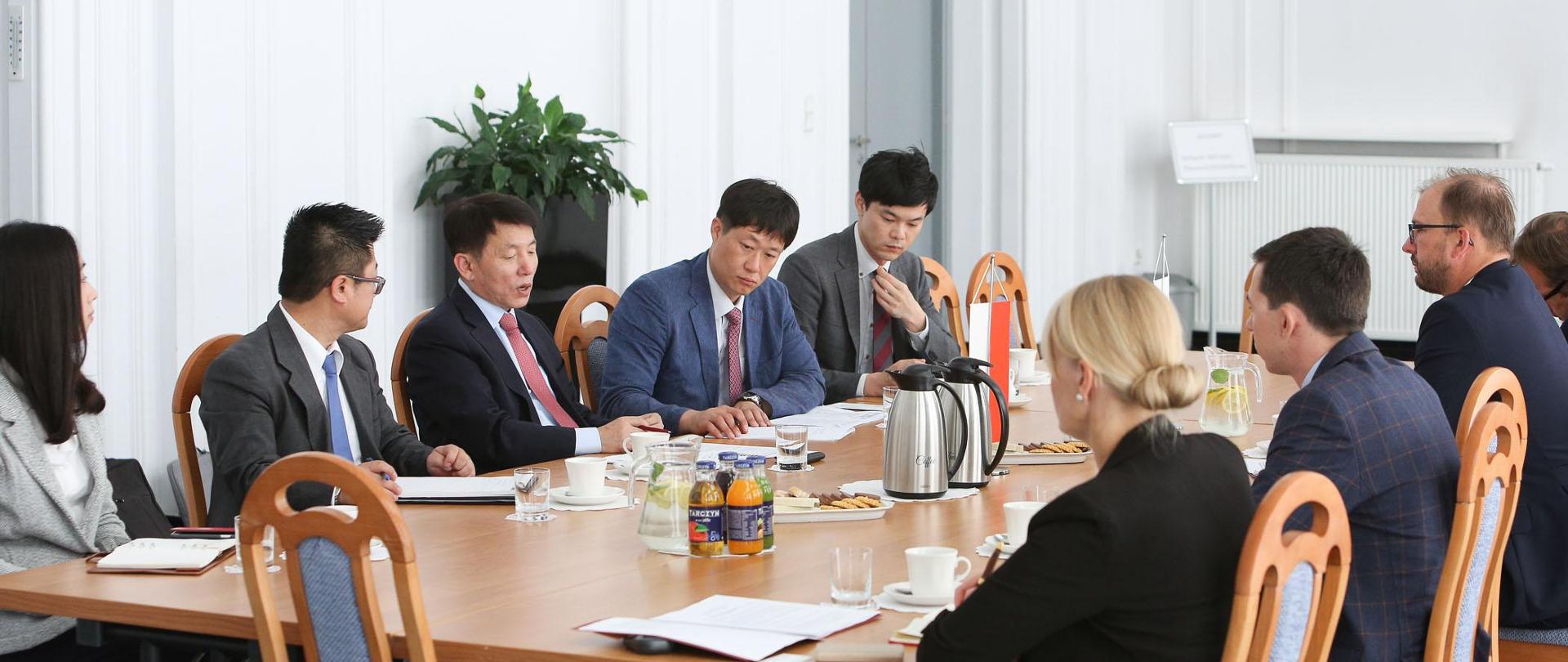 Delegacja koreańska siedzi za stołem naprzeciwko przedstawicieli MNiSW