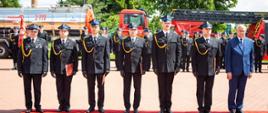 Komendant i Minister z odznaczonymi strażakami.