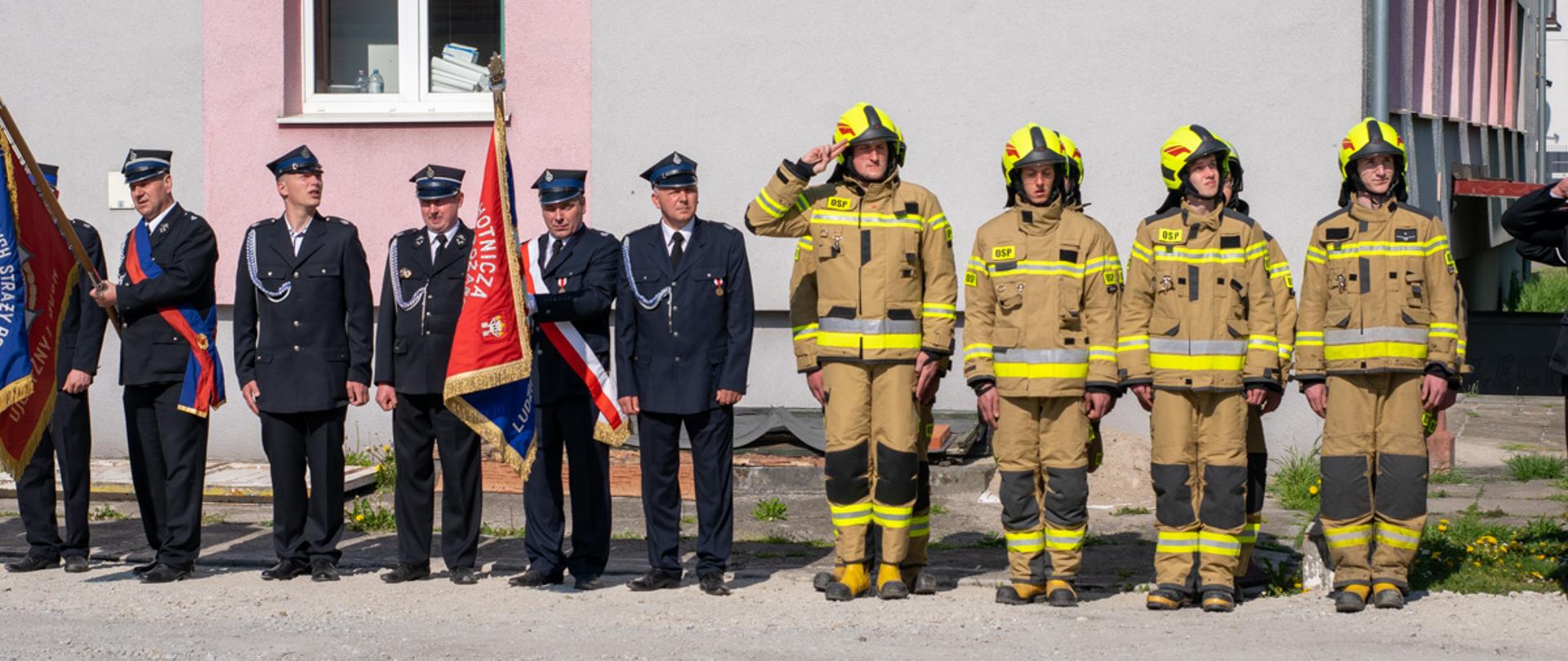 Na zdjęciu druhowie OSP w ubraniach specjalnych oraz poczty sztandarowe OSP