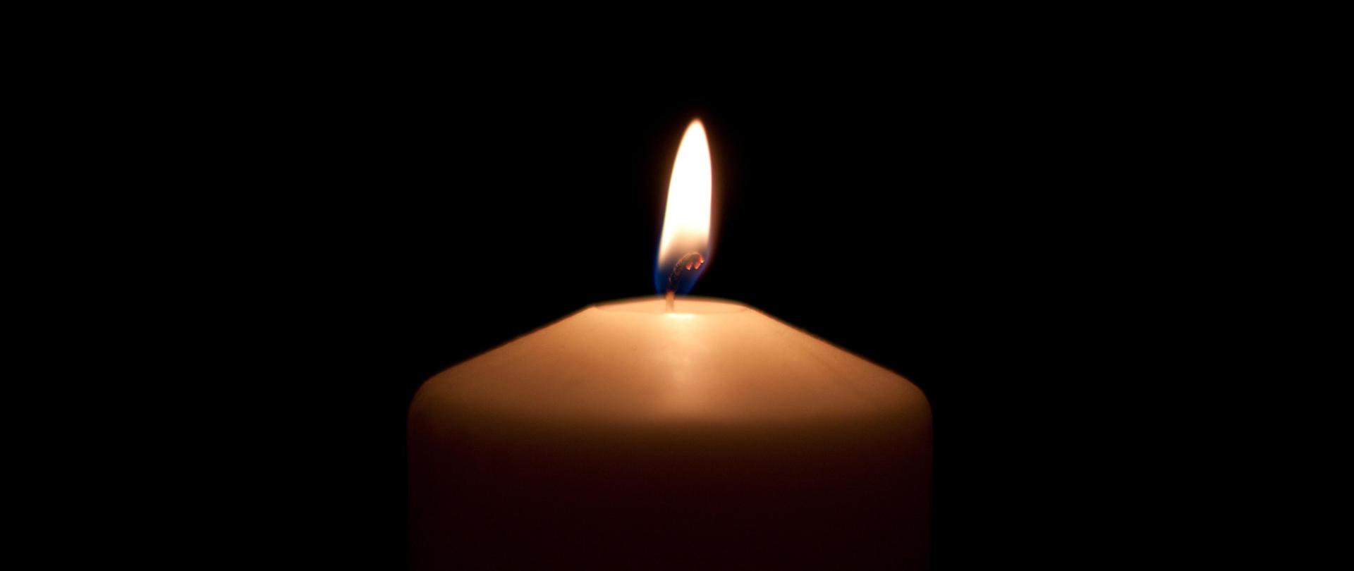 Zapalona świeca na czarnym tle