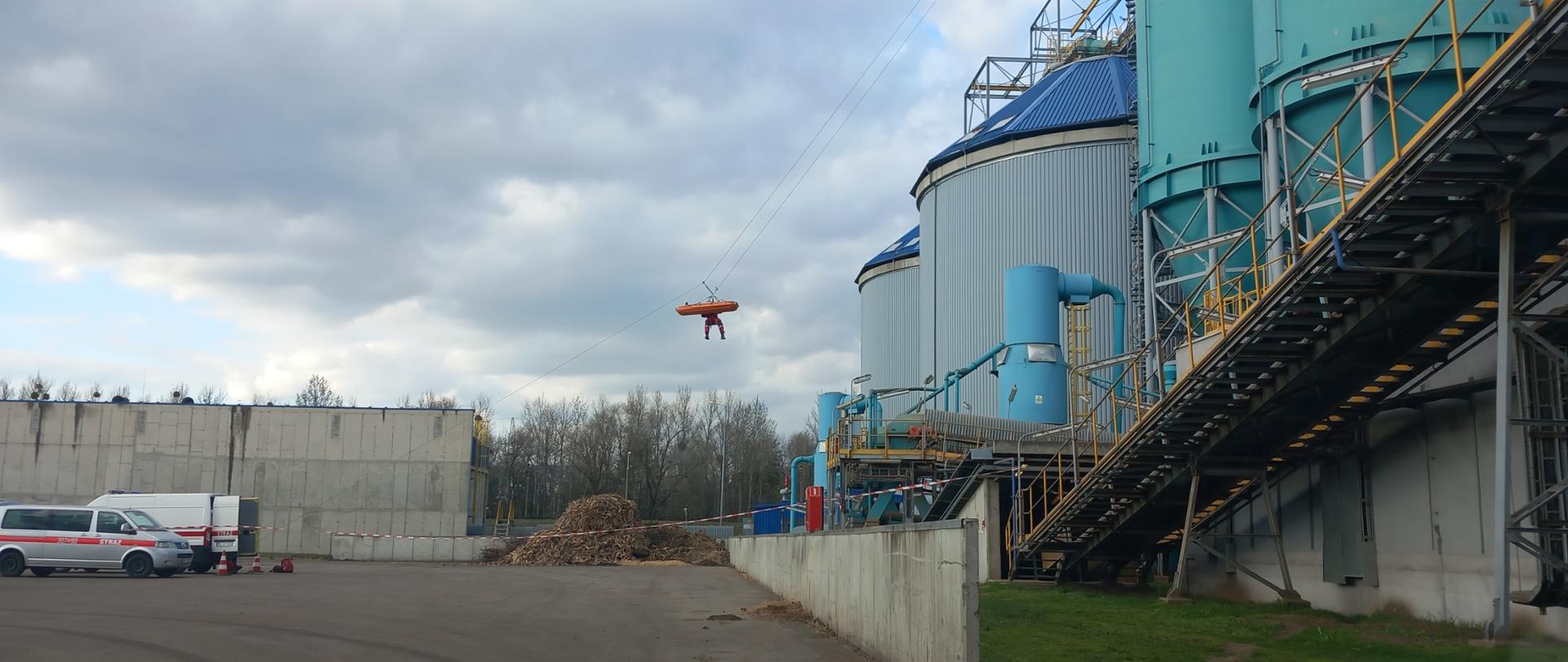 Ratownik z poszkodowanym zjeżdża ze zbiorników biomasy