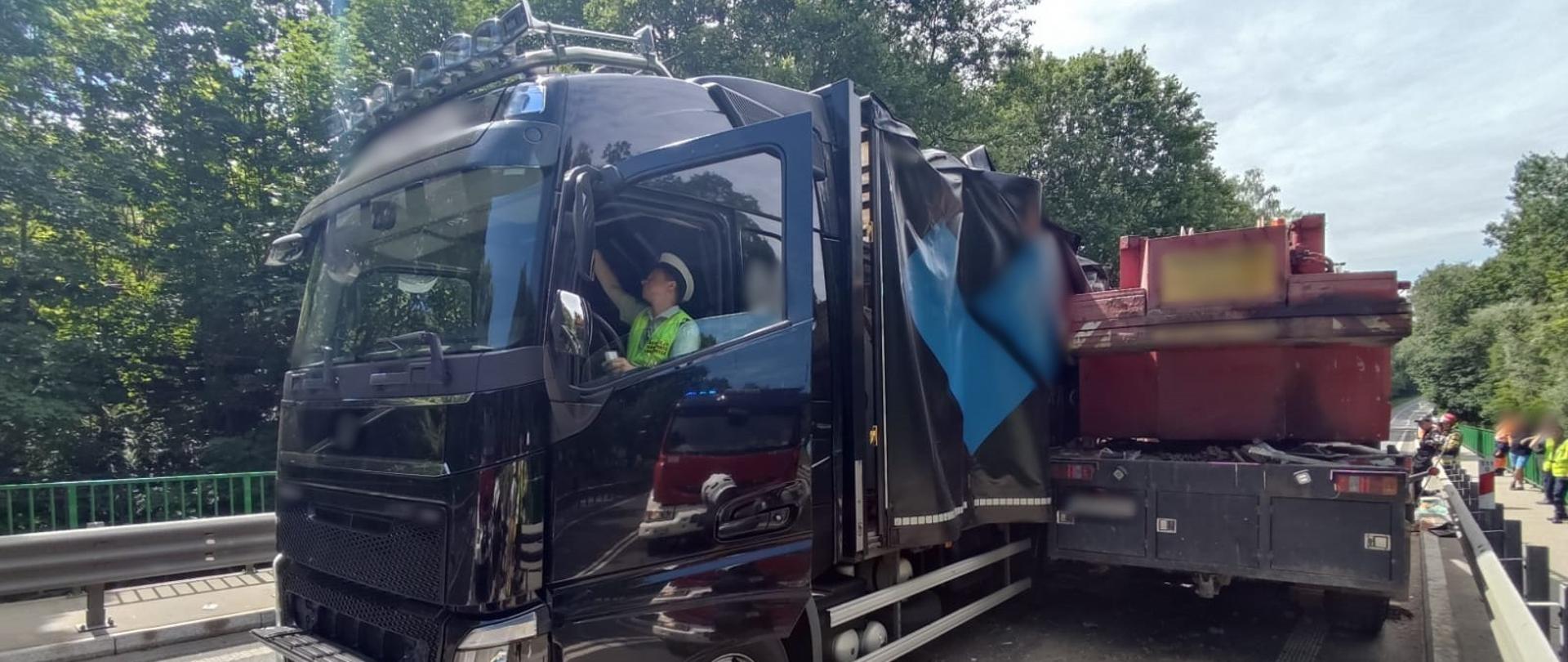 Inspektor warmińsko-mazurskiej ITD siedzi w kabinie ciężarówki i pobiera dane z pamięci tachografu.