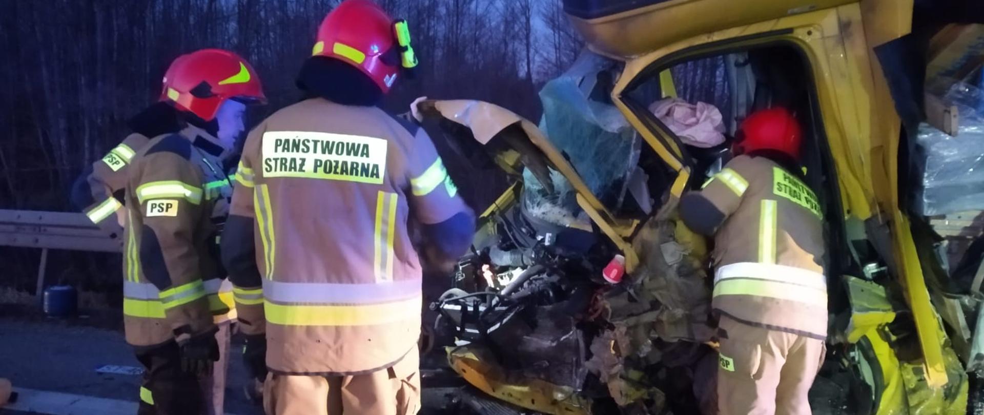 3 strażaków prowadzi działania przy uszkodzonym samochodzie dostawczym